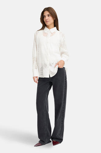 Wit overhemd met lange mouwen van PULZ, met subtiele textuur en gedragen met zwarte jeans.
