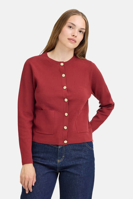 Gilet rouge de PULZ, vu du l'arrière, porté avec un jeans bleu foncé.