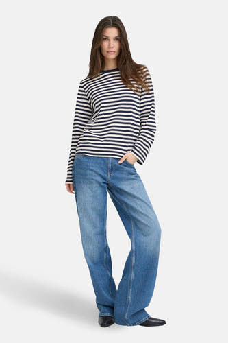 T-shirt bleu rayé à manches longues de PULZ, porté avec des jeans larges et des chaussures noires.