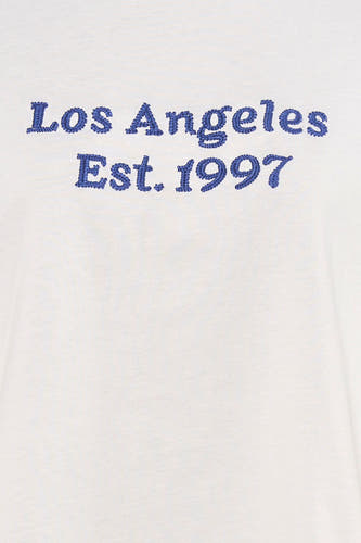 T-shirt blanc de PULZ, brodé de "Los Angeles Est. 1997" en bleu.