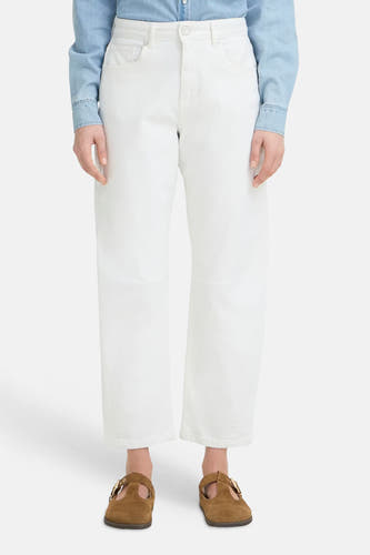 Jeans large blanc en denim de PULZ avec jambes raccourcies et poches arrière, portées avec une chemise en denim bleu clair et des mules marron.
