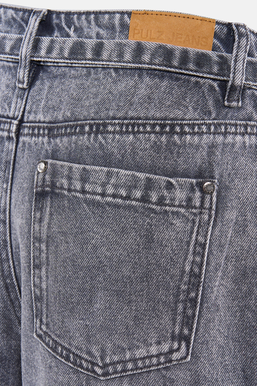 Bermuda en denim gris de PULZ avec un patch logo en cuir et une poche arrière à rivets.