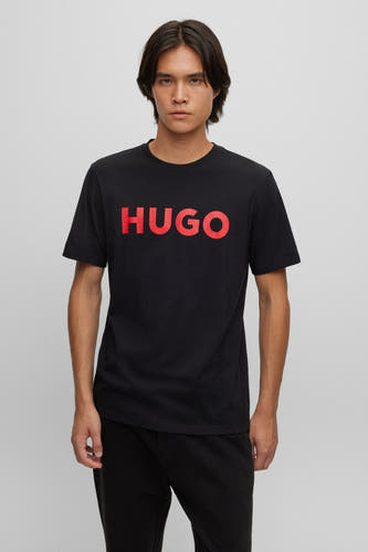T-shirt noir à manches courtes de HUGO, avec des lettres rouges sur la poitrine.