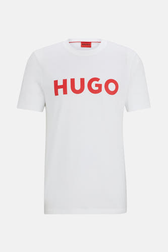 T-shirt blanc à manches courtes de HUGO, avec le nom de marque rouge sur l'avant et une étiquette rouge dans le col.