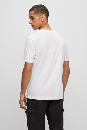 Wit T-shirt van HUGO, gezien van achteren, gecombineerd met een zwarte broek met zakken.
