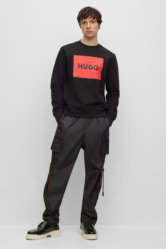 Gilet noir HUGO, avec un logo rouge vif sur la poitrine.