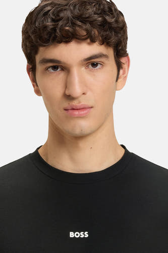 T-shirt noir à manches courtes de HUGO BOSS ORANGE, portrait rapproché d'un homme portant le t-shirt.