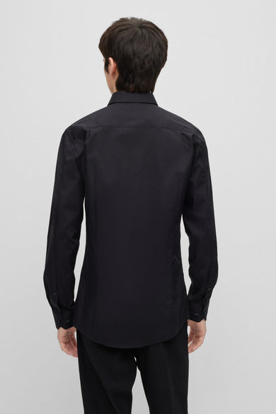Chemise noire à manches longues de HUGO, vue de derrière, associée à un pantalon noir.