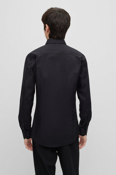 Chemise noire à manches longues de HUGO, vue de derrière, associée à un pantalon noir.