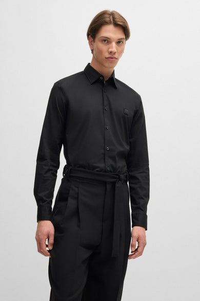 Chemise noire à manches longues de HUGO, avec fermeture à boutons visible et logo sur la poitrine.