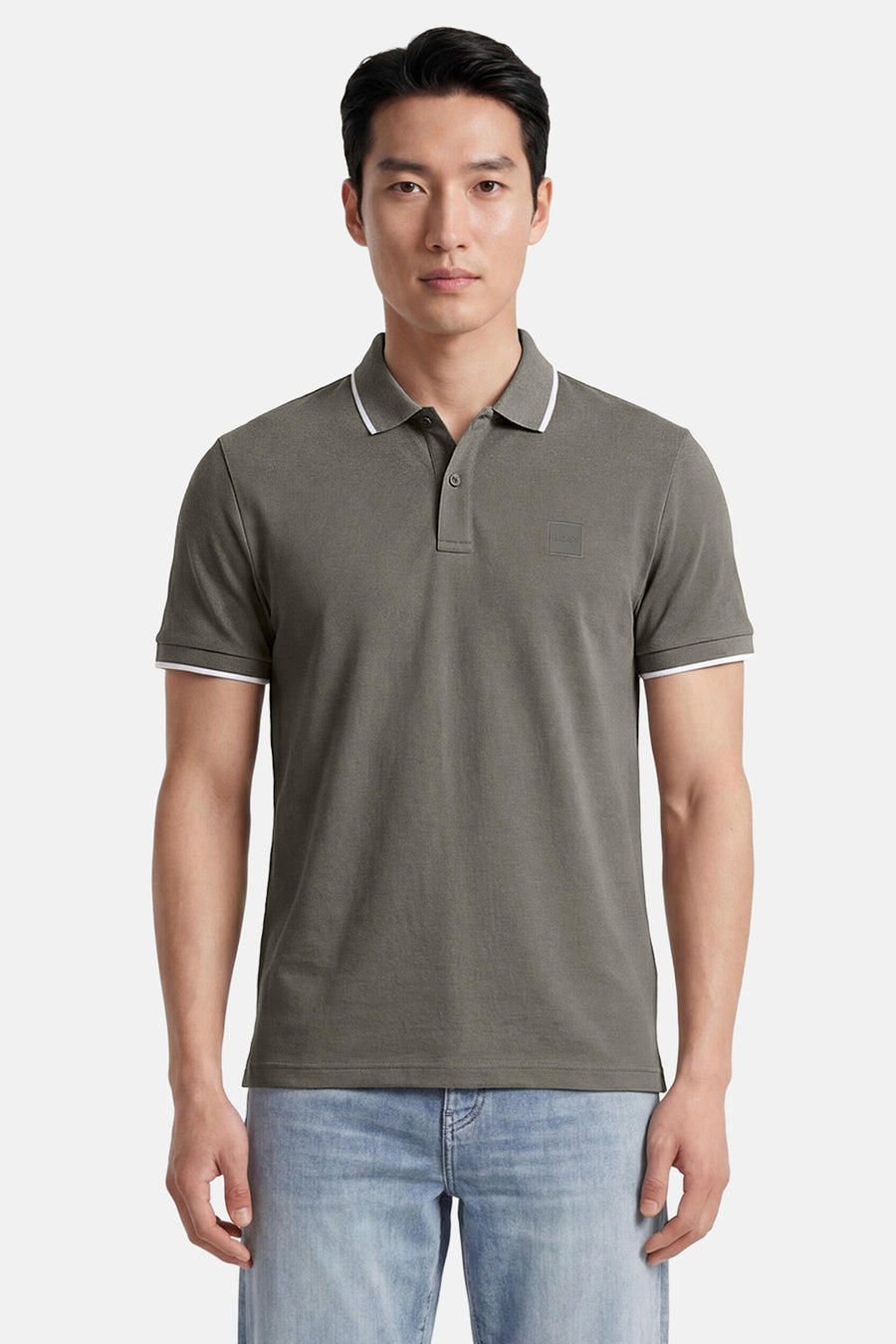 Kakikleurige polo van HUGO BOSS ORANGE met klassieke kraag, twee knopen, witte biezen en een ton-sur-ton BOSS-patch op de borst.