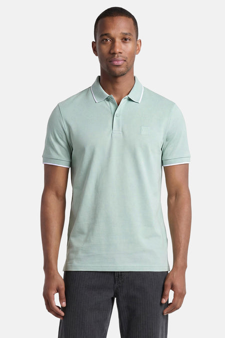 Polo turquoise HUGO BOSS ORANGE avec passepoil blanc sur le col et les poignets, et un logo carré.