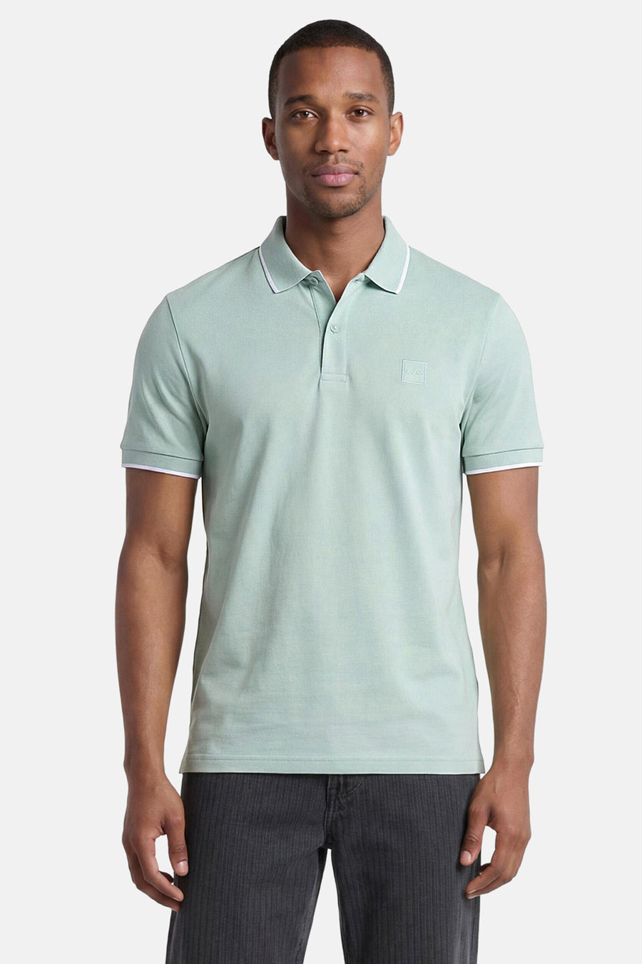 Polo turquoise HUGO BOSS ORANGE avec passepoil blanc sur le col et les poignets, et un logo carré.