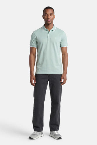 Polo turquoise HUGO BOSS ORANGE avec passepoil blanc sur le col et les manches, porté par un homme avec un pantalon foncé et des baskets grises.