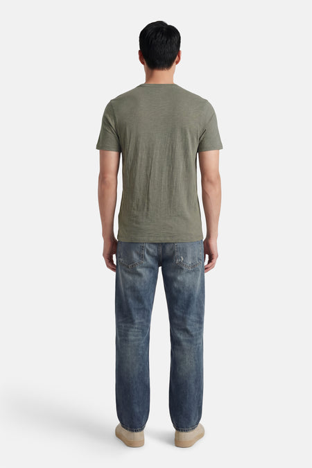 T-shirt à manches courtes HUGO BOSS ORANGE, vu de dos, porté avec un jean bleu et des chaussures crème.