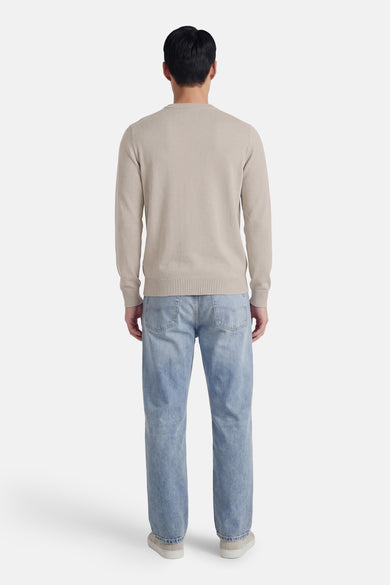 Pull gris à col rond de HUGO BOSS ORANGE, vu de dos, combiné avec un jean bleu et des chaussures claires.