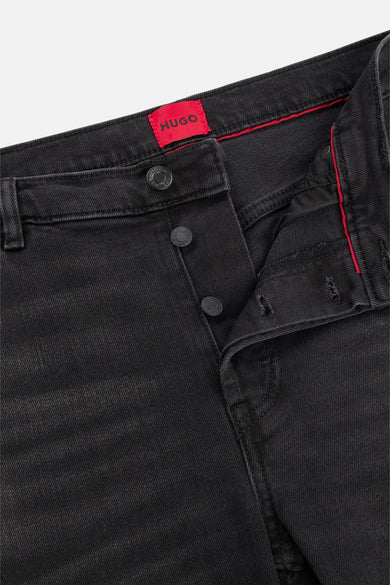 Jean tapered noir en denim de HUGO, avec fermeture à boutons et accents rouges à l'intérieur.