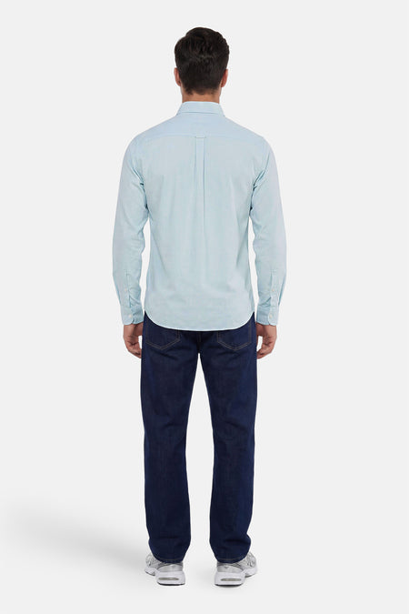 Achterzicht van een lichtblauw overhemd van HUGO BOSS ORANGE met lange mouwen en een plooi op de rug, gedragen door een man in donkere spijkerbroek en sneakers.