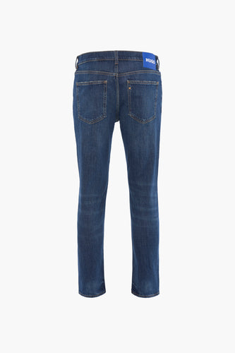 Donkerblauwe jeans van achteren gezien met een blauw Hugo-label.