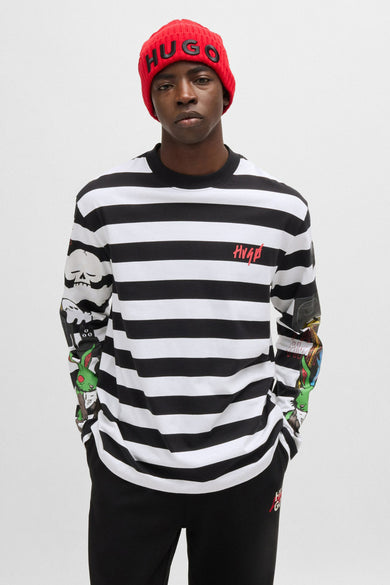 T-shirt à manches longues rayé noir et blanc de HUGO avec logo rouge sur la poitrine et illustrations colorées sur les manches.