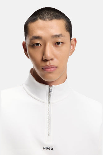 Man met kort kapsel in een witte Hugo-sweater.