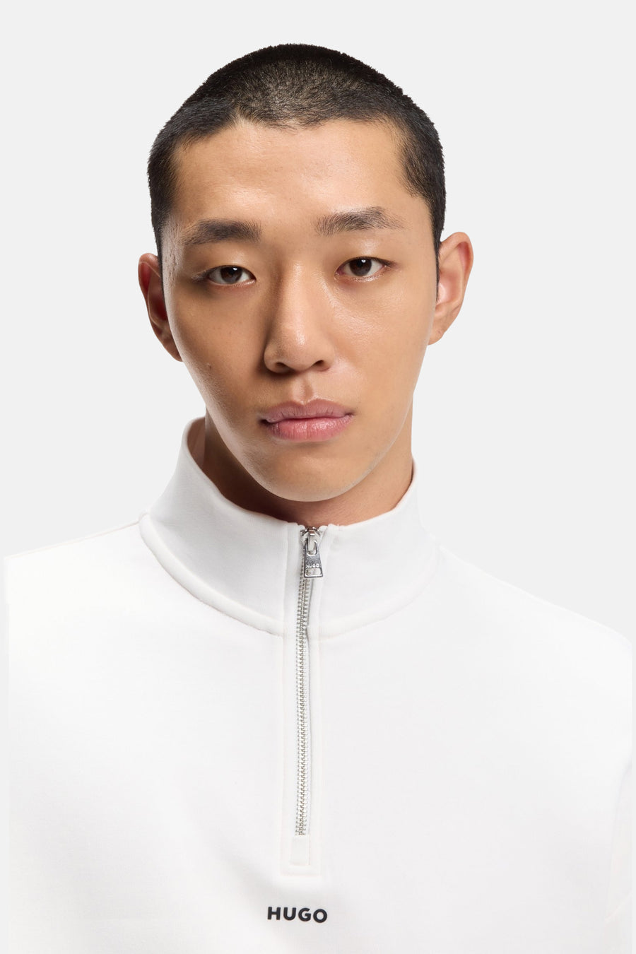 Man met kort kapsel in een witte Hugo-sweater.