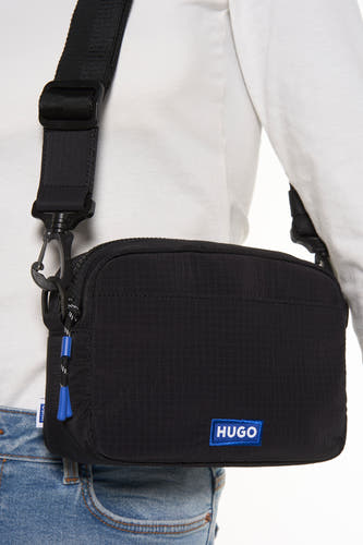 Sac à dos noir HUGO BLUE, avec des bretelles ajustables et des accents bleus sur la fermeture éclair.