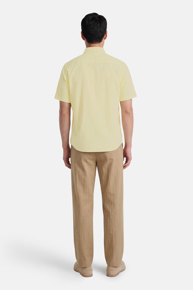 Chemise jaune à manches courtes de HUGO BOSS ORANGE, vue de dos, avec pantalon et chaussures marron.