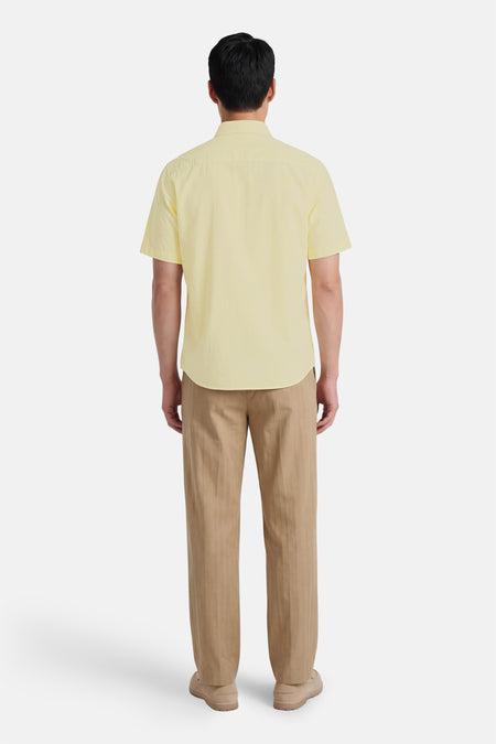 Chemise jaune à manches courtes de HUGO BOSS ORANGE, vue de dos, avec pantalon et chaussures marron.