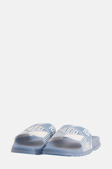Chaussons bleus HUGO, avec imprimé logo blanc et motif graphique sur la semelle.