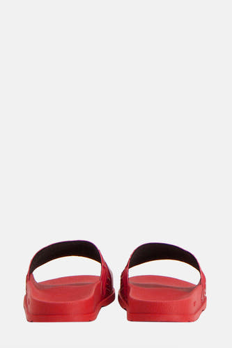 Chaussons rouges de HUGO, avec une doublure noire et des semelles plates, vus par derrière.