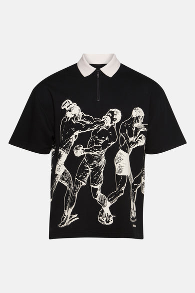 T-shirt polo noir à manches courtes de HUGO, avec une collet et un im impression graphique sur la devant.