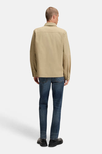 Chemise beige à longues manches de HUGO, vue de derrière, portée avec des jeans bleus marine et des chaussures noires.