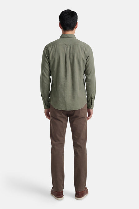 Chemise grise à manches longues HUGO BOSS ORANGE, vue de dos, associée à un pantalon marron et des chaussures marron.