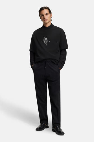Zwart T-shirt met korte mouwen van HUGO, met een grafische print en gedragen met een lange mouwen shirt en een pantalon.
