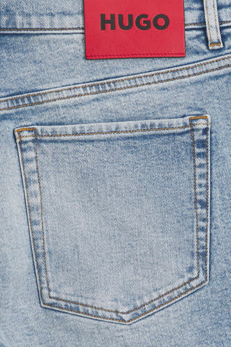 Lichtblauwe jeansshort van spijkerstof van HUGO, met een opgestikte achterzak en een rode HUGO-merkpatch bovenaan.