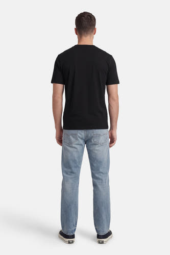 T-shirt noir à manches courtes de HUGO, vu de dos, associé à un jean bleu et des baskets foncées.