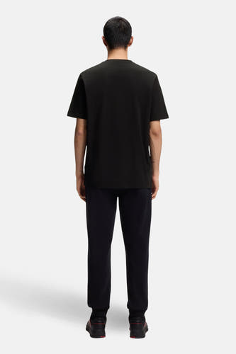 Zwart T-shirt met korte mouwen van HUGO, gezien vanaf de achterkant, gecombineerd met een donkere broek.

