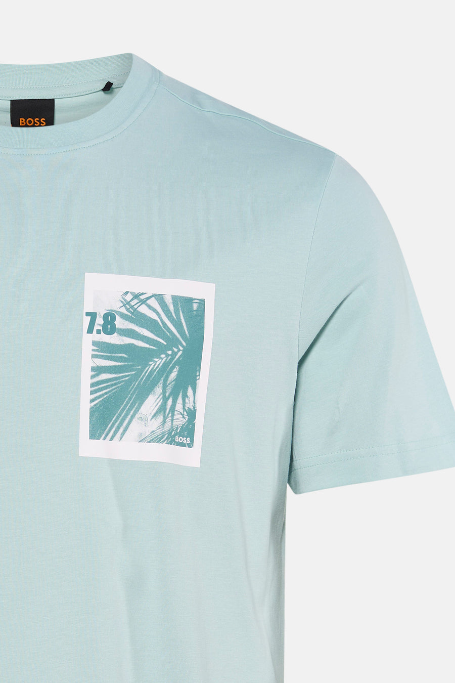 T-shirt turquoise à manches courtes de HUGO BOSS ORANGE, avec un imprimé blanc de feuilles de palmier et '7.8' sur la poitrine.