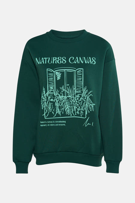 Pull-over vert de 24 Colours GMBH, avec une impression d'une fenêtre avec des plantes et du texte.