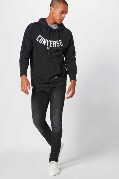 Jean skinny gris G-Star RAW, avec un effet froissé et porté avec une hoodie noire à logo de marque.