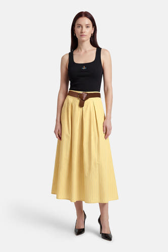 Jupe jaune de Terra di Siena, à rayures verticales, combinée avec un haut noir et une ceinture marron.