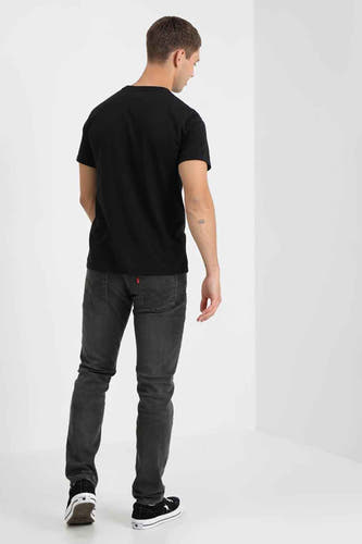T-shirt noir de Levi's, à manches courtes, porté avec des jeans gris et des baskets noires, photographié depuis l'arrière.