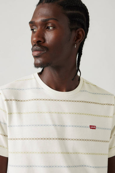 Man met gevlochten haar draagt gestreepte Levi's T-shirt.