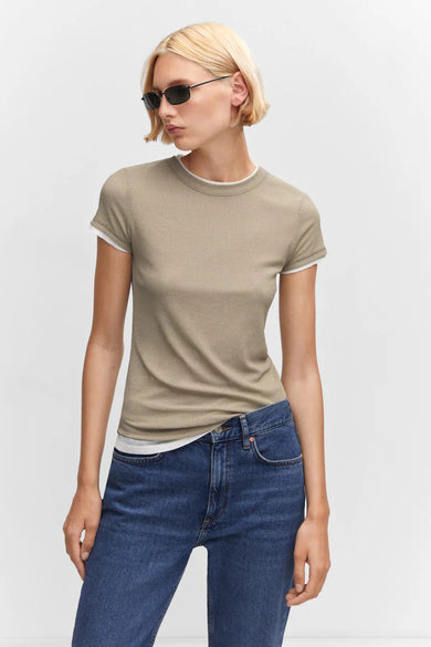 T-shirt côtelé vert olive de MANGO avec liseré blanc au col et aux manches, porté avec un jean bleu, vue de face