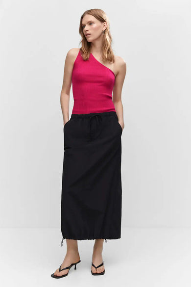 Haut côtelé rose sans manches de MANGO, design asymétrique à l'épaule, porté avec une jupe longue noire et des sandales, vue de face.