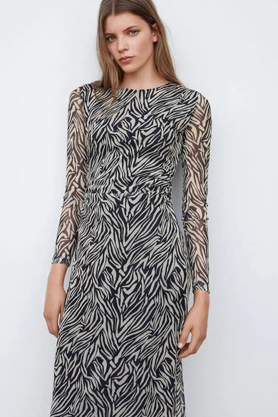 Robe noire à longues manches de MANGO, avec un imprimé zèbre et un détail plissé.