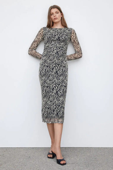 Robe noire à longues manches de MANGO, avec imprimé zèbre, coupe ajustée et petites poches noires.