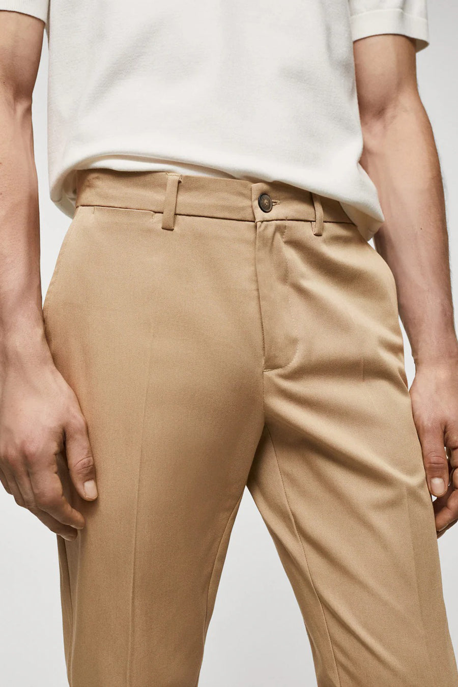 Chino marron de MANGO, avec une élégante pliure et un subtil éclat.