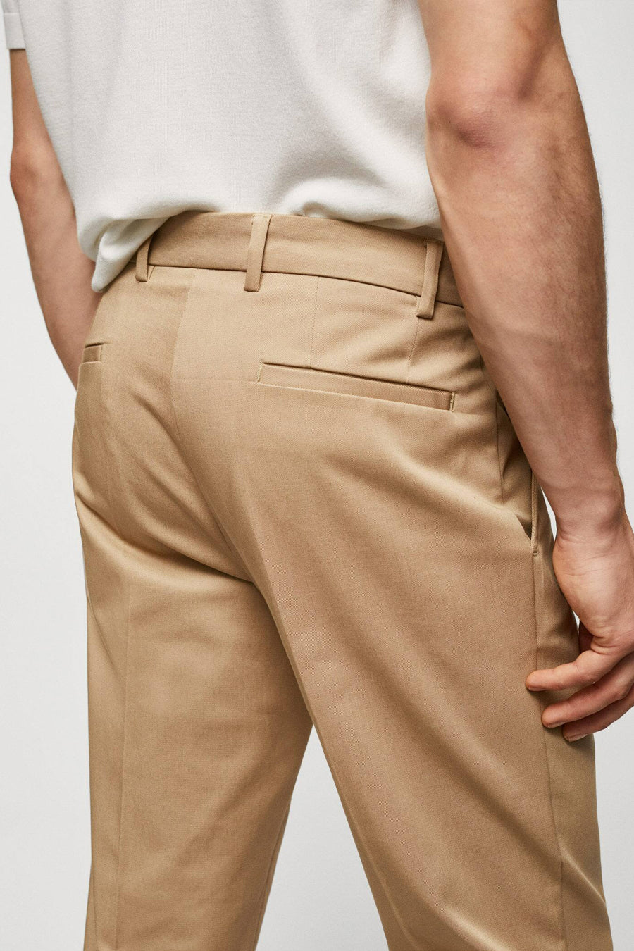 Jean chino marron de MANGO, avec poche arrière et passants, porté avec un T-shirt blanc.